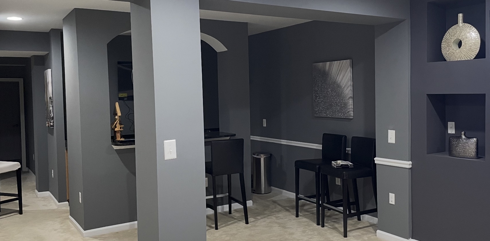 Finished basement with gray painted walls and bar area